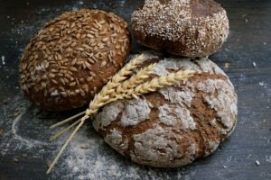 Mehrere Brotsorten aus Getreide mit einer Ähre darüber
