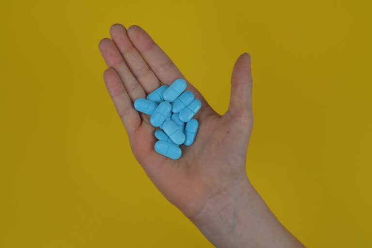Eine Hand voll blauer Pillen Alpha Liponsäure.